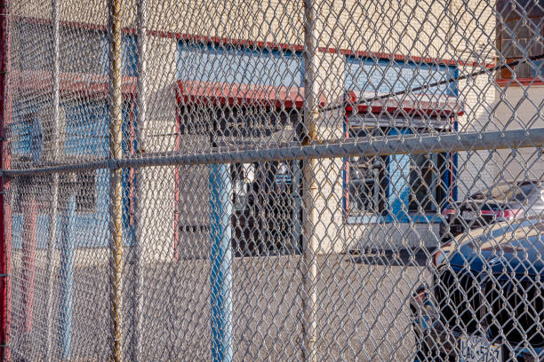 Long Island City, Queens, New York, United States - January 10th 2025:  Chain link fence around a small parking lot in a part of the city with small industries