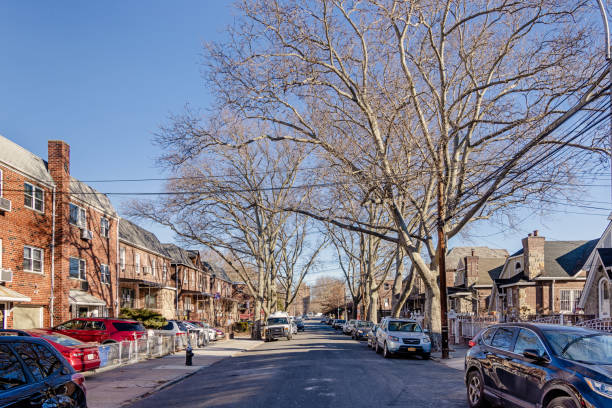 Long Island City, Queens, New York, United States - January 10th 2025:   View up a street with three-story residential houses on a clear winter day