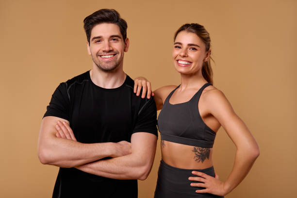 istock An Energetic Fitness Duo is Posing Confidently Against a Warm and Inviting Backdrop 2197205879