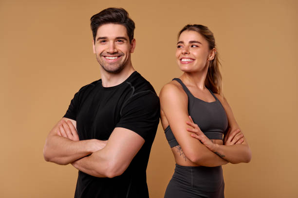 istock An Energetic Fitness Duo is Posing Confidently Against a Warm and Inviting Backdrop 2197205893