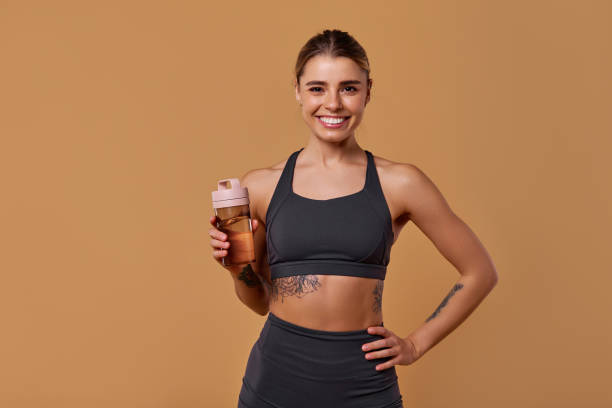 istock Confident Woman Dressed in Stylish Activewear While Holding a Protein Shake Proudly 2197205929