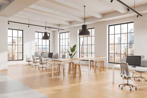 istock Modern open office space with large windows, wooden flooring, desks, chairs, and plants, providing a bright and collaborative work environment. 3D Rendering 2197206483