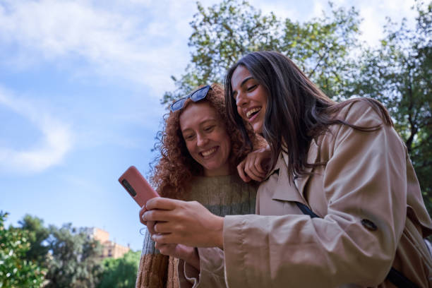 istock Two smiling women friends using phone togather. 2197206622