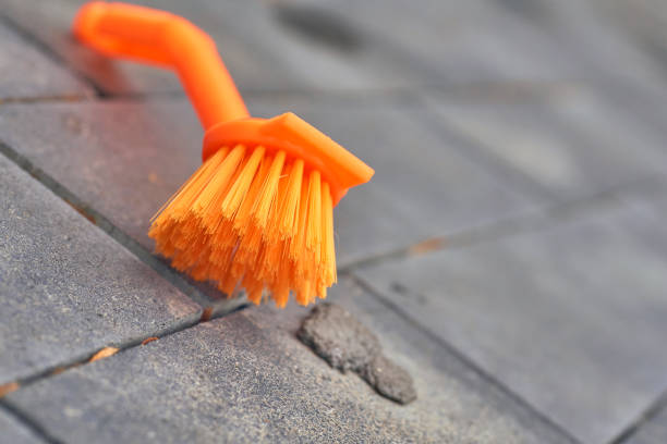 istock Orange brush for cleaning. Stone tiles, paving 2197209049