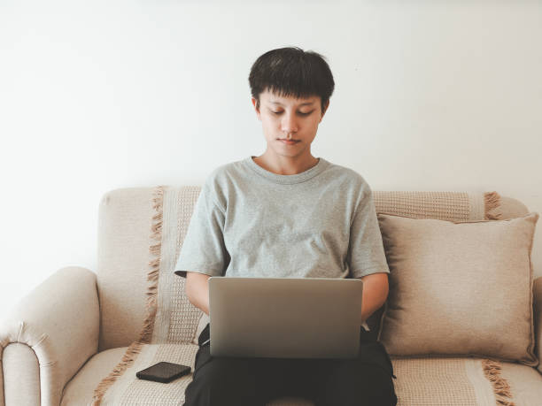 istock Man working on laptop on sofa at home 2197209894