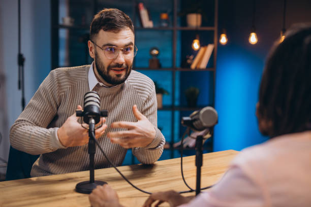 istock Two podcasters engaging in a lively conversation while recording a new episode in a professional studio filled with advanced equipment 2197212055