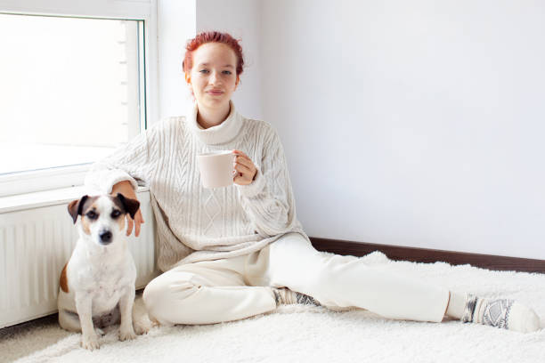 istock Young Woman Drinking hot coffee at white room 2197212196