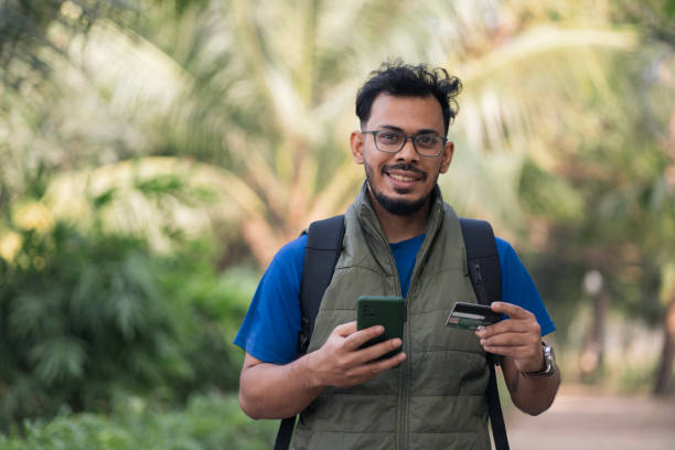 istock Happy Young Man Making an Online Payment Outdoors 2197212488