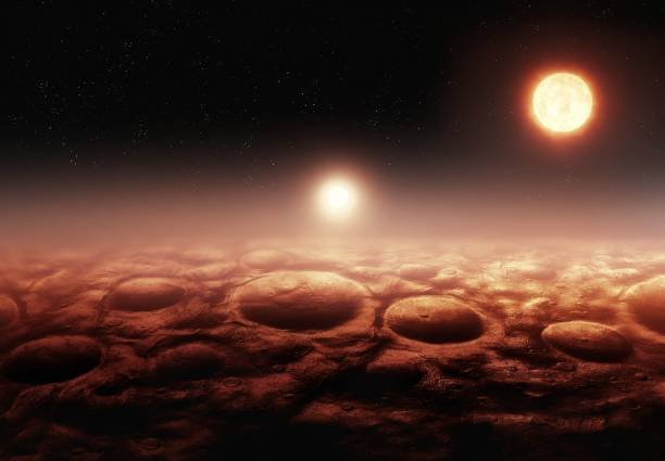 istock Two suns over an exoplanet. Alien surface with impact craters. 2197213542