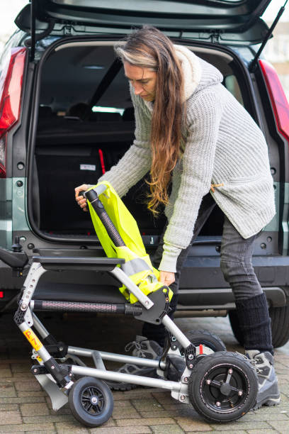 istock Person loading foldable wheelchair into car trunk 2197213787