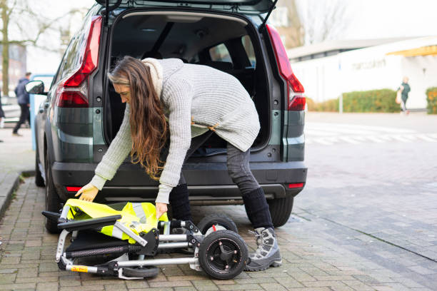 istock Woman loading foldable wheelchair into car trunk 2197213795