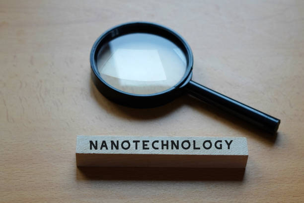 istock nanotechnology. magnifying glass and letters written on wooden table 2197215362