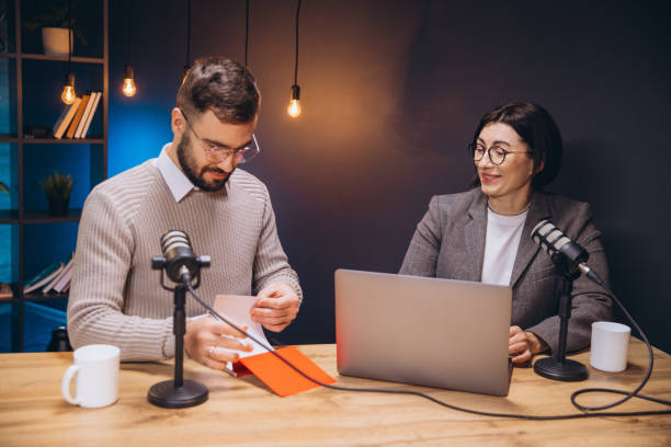 istock Professional podcasters collaborating, using laptop while recording audio episode in soundproofed studio, capturing conversational moment 2197215722