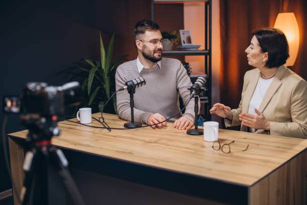istock Two podcasters are recording a new episode in a professional studio, engaging in conversation and sharing their expertise 2197216118