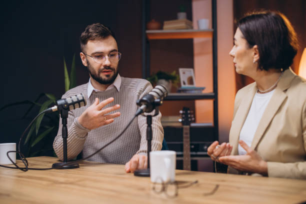 istock Professional podcasters recording audio using studio microphones within dynamic radio station workspace 2197216159