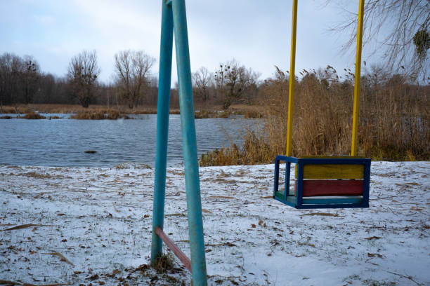 Lonely swing by the lake is boring on a windy day in the off-season