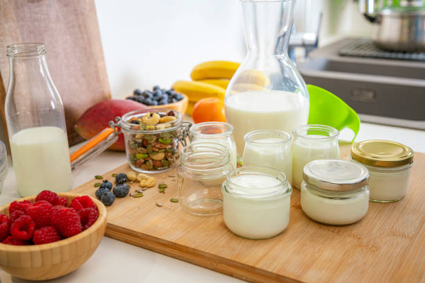 Group of glass containers filled with freshly prepared yogurt on kitchen counter