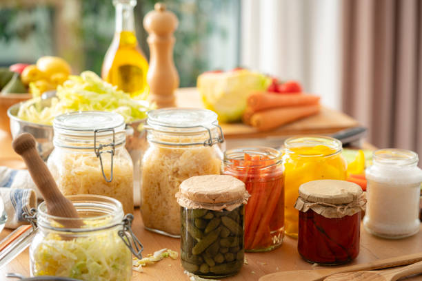 Various fermented and pickled vegetables in glass jars on kitchen table