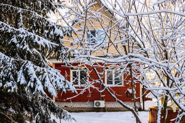 vew of small wooden country house from snowy backyard on winter day