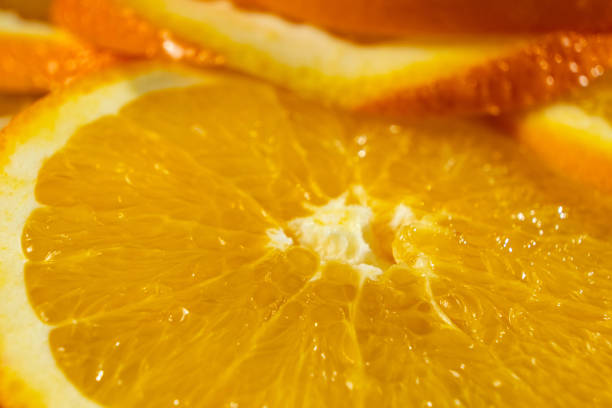 Orange background, ripe oranges cut into slices close-up
