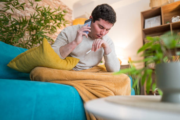 istock sick man sitting on the sofa in the living room 2197225021