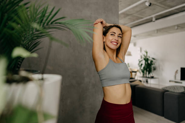 istock Young woman stretching arms at home after workout 2197225429