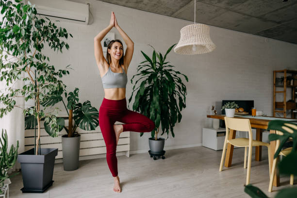 Young Woman Practicing Yoga Tree Pose at Home