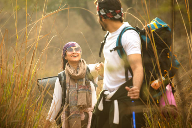 istock Young couple holding hands and hiking in forest 2197226433