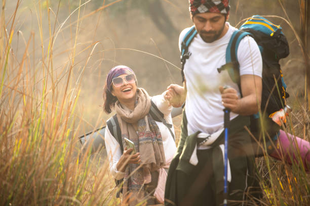 istock Young couple holding hands and hiking in forest 2197226472