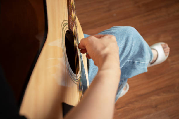 istock Hand Playing Acoustic Guitar Close-Up, musician practicing chords, guitarist strumming strings, hobby of playing music 2197228991