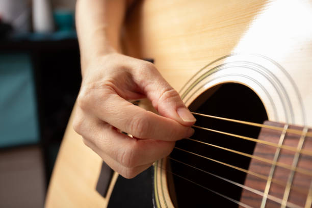 istock Hand Playing Acoustic Guitar Close-Up, musician practicing chords, guitarist strumming strings 2197229009