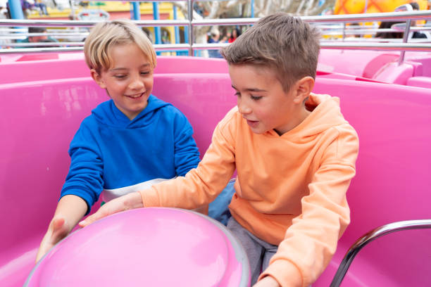 istock Two young boys having fun on a spinning carousel at an amusement park 2197231852