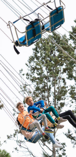 istock Children having fun on a swing ride at an amusement park 2197231892