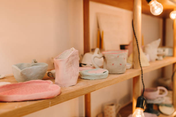 istock Shelf with handmade clay cups and plates in the pottery studio. Creating ceramics ware with own hands. 2197232036