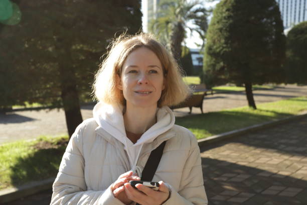 istock Woman using smartphone outdoors in city, holding a digital device for texting and chatting, exploring lifestyle apps in a modern urban environment. 2197233022