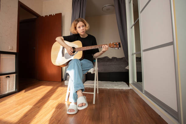 istock Guitarist learning at home, person exploring chords on a classic instrument, dedicated study of string techniques and musical performance. 2197233091