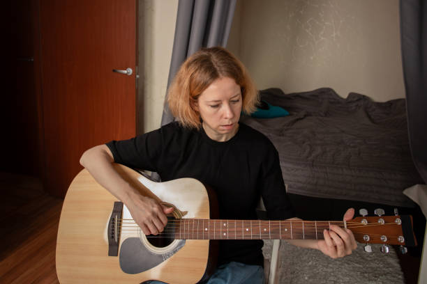 istock Guitar lessons at home, musician teaching chords to a beginner, lifestyle focused on skill development. 2197233125
