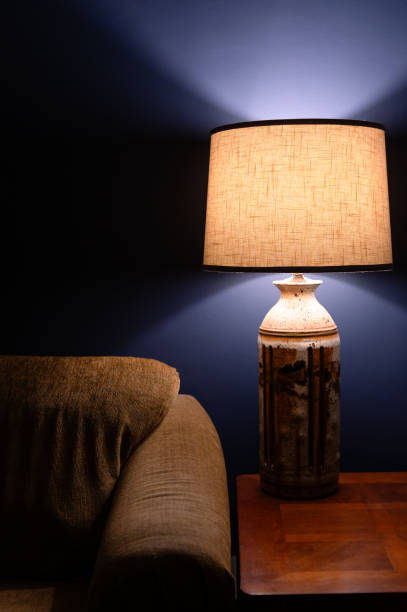 istock Table lamp next to gold couch and a blue wall 2197233542