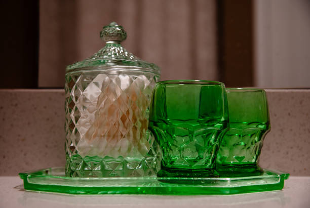 Green drinking glasses and canister on bathroom counter