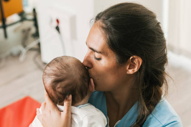 istock Nurse kissing baby's head during physiotherapy session 2197234434