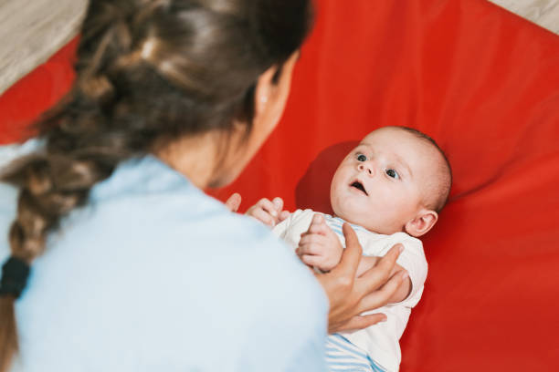 istock Physiotherapist doing exercises with a baby on red mat 2197234522