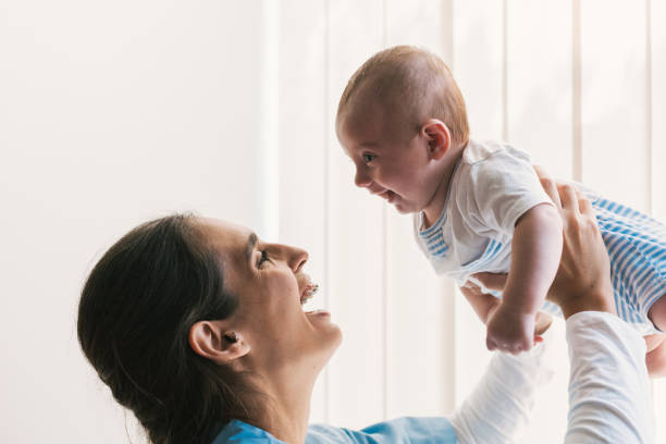 istock Physiotherapist lifting and playing with a baby during therapy session 2197234581