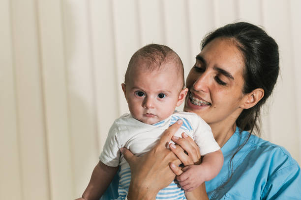 istock Young physiotherapist holding a baby during therapy session 2197234641
