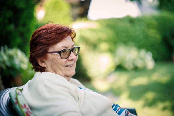 Close-Up Portrait Of Senior Woman With Rainbow On Face Wearing Eyeglasses