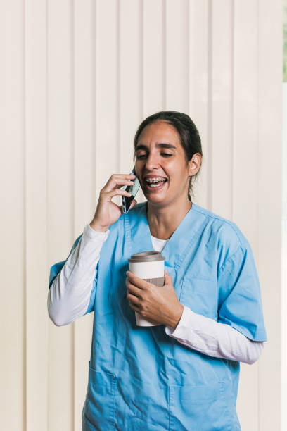 istock Smiling nurse talking on phone and holding coffee 2197236335
