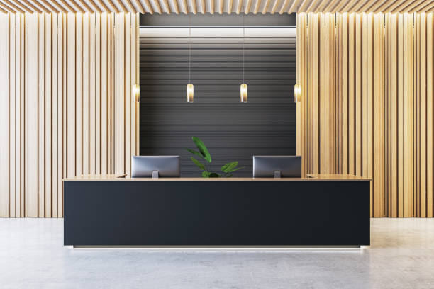 istock Modern reception desk in a luxurious office interior with wooden panel walls and hanging pendant lights. 3D Rendering 2197239785