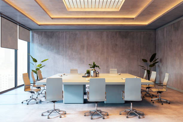istock Modern conference room with a large table, chairs, and plants, featuring concrete walls and ceiling lighting. 3D Rendering 2197239885