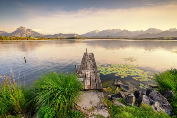 beautiful calm sunset at the beach on a mountain lake with jetty