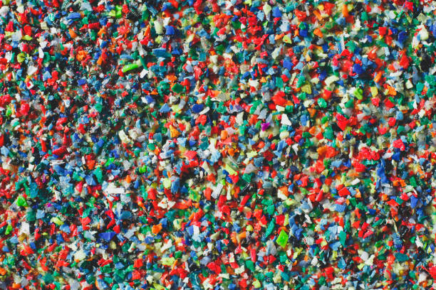 istock Multicolored recycled plastic granules in various shapes and sizes, creating a vibrant texture. The image represents sustainability, waste management, and environmental awareness 2197240351