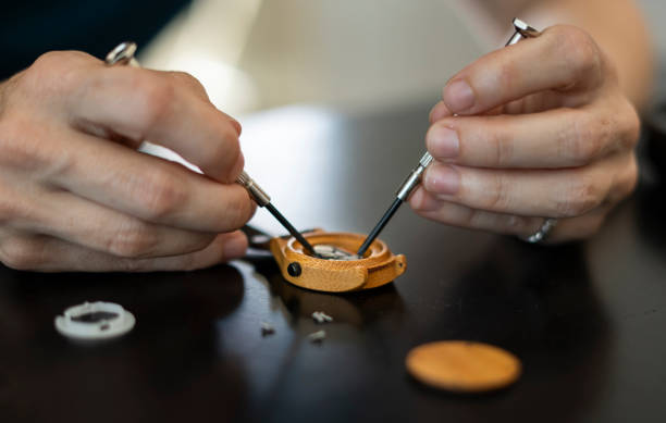 istock Woman watchmaker repairing wristwatch using tools in workshop 2197247705